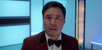 Movie still from “Always Be My Maybe” (2019), directed by Nahnatchka Khan – A person wearing a suit and a bow tie; Close Up shot, Over the shoulder angle
