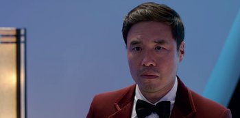 Movie still from “Always Be My Maybe” (2019), directed by Nahnatchka Khan – A person wearing a suit and bow tie; Close Up shot, Low angle