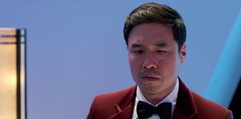 Movie still from “Always Be My Maybe” (2019), directed by Nahnatchka Khan – A person wearing a suit and bow tie; Close Up shot, Low angle