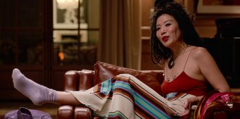 Movie still from “Always Be My Maybe” (2019), directed by Nahnatchka Khan – A woman sitting on top of a brown leather couch; Medium shot, High angle