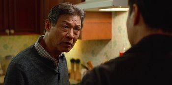 Movie still from “Always Be My Maybe” (2019), directed by Nahnatchka Khan – An older asian man standing in front of a counter; Close Up shot, Over the shoulder angle
