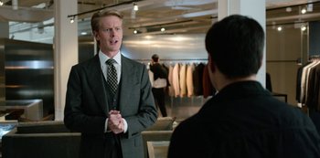 Movie still from “Always Be My Maybe” (2019), directed by Nahnatchka Khan – A man in a suit talking to another man in a suit in a suit shop; Medium shot, Over the shoulder angle