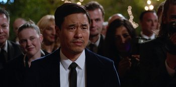 Movie still from “Always Be My Maybe” (2019), directed by Nahnatchka Khan – A person wearing a suit and a tie; Close Up shot, Over the shoulder angle