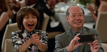 Movie still from “Always Be My Maybe” (2019), directed by Nahnatchka Khan – A man and a woman clapping in front of each other; Medium shot, Over the shoulder angle