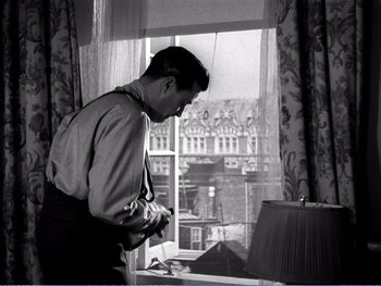Movie still from “The Lost Weekend” (1945), directed by Billy Wilder – A black and white photo of a man standing in front of a window; Medium shot, Low angle