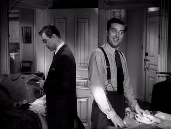 Movie still from “The Lost Weekend” (1945), directed by Billy Wilder – A man in a suit and tie standing next to another man in a suit and tie; Medium shot, Over the shoulder angle