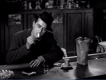 Movie still from “The Lost Weekend” (1945), directed by Billy Wilder – A black and white photo of a man smoking a cigarette; Medium shot, Low angle