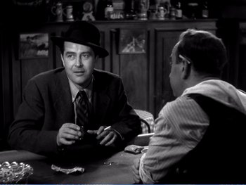 Movie still from “The Lost Weekend” (1945), directed by Billy Wilder – Two men sitting at a table talking to each other; Medium shot, Over the shoulder angle