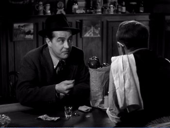Movie still from “The Lost Weekend” (1945), directed by Billy Wilder – An old photo of a man sitting at a table talking to a young boy; Medium shot, Over the shoulder angle