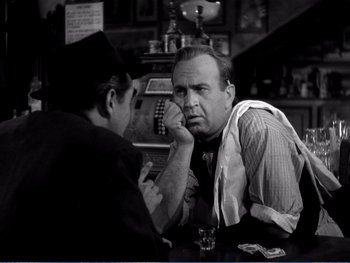 Movie still from “The Lost Weekend” (1945), directed by Billy Wilder – Two men sitting at a table in front of a phone; Medium shot, Over the shoulder angle