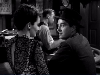 Movie still from “The Lost Weekend” (1945), directed by Billy Wilder – A black and white photo of a man and a woman sitting at a table; Medium shot, Over the shoulder angle