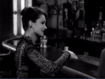 Movie still from “The Lost Weekend” (1945), directed by Billy Wilder – A black and white photo of a woman sitting at a bar; Medium shot, High angle