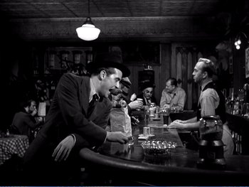 Movie still from “The Lost Weekend” (1945), directed by Billy Wilder – A group of people sitting at a bar; Wide shot, Over the shoulder angle