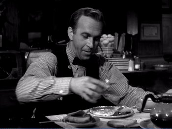 Movie still from “The Lost Weekend” (1945), directed by Billy Wilder – A man sitting at a table with food in front of him; Medium shot, High angle