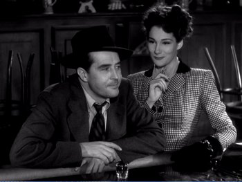 Movie still from “The Lost Weekend” (1945), directed by Billy Wilder – A man and a woman sitting at a table together; Medium shot, High angle