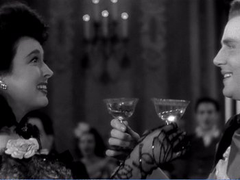 Movie still from “The Lost Weekend” (1945), directed by Billy Wilder – A woman holding two glasses of wine up to her face; Close Up shot, Over the shoulder angle