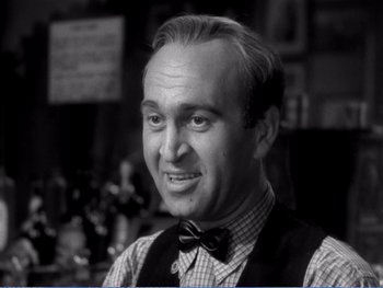 An older man wearing a vest and bow tie
