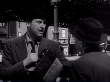 Movie still from “The Lost Weekend” (1945), directed by Billy Wilder – A man talking to another man on a street corner; Medium shot, Over the shoulder angle