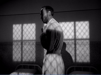 Movie still from “The Lost Weekend” (1945), directed by Billy Wilder – A black and white photo of a man in a robe; Medium shot, Low angle