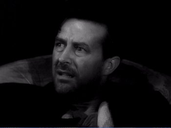 A black and white photo of a man with his eyes wide open
