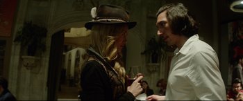 Movie still from “The Man Who Killed Don Quixote” (2018), directed by Terry Gilliam – A woman wearing a hat and holding a glass of wine; Medium shot, Over the shoulder angle