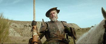 Movie still from “The Man Who Killed Don Quixote” (2018), directed by Terry Gilliam – An old man dressed as a medieval knight holding a sword; Medium shot, Low angle