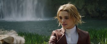 Movie still from “The Man Who Killed Don Quixote” (2018), directed by Terry Gilliam – A woman wearing a brown jacket near a body of water; Close Up shot, Over the shoulder angle