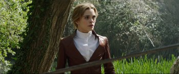 Movie still from “The Man Who Killed Don Quixote” (2018), directed by Terry Gilliam – A woman in a brown jacket standing next to a tree; Medium shot, Over the shoulder angle