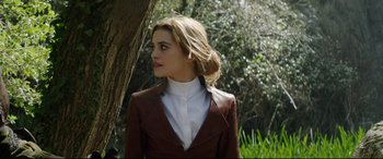 Movie still from “The Man Who Killed Don Quixote” (2018), directed by Terry Gilliam – A woman in a brown jacket standing next to a tree; Medium shot, Low angle