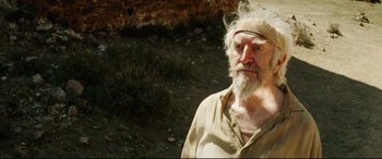 Movie still from “The Man Who Killed Don Quixote” (2018), directed by Terry Gilliam – An old man with a white beard is posing for a picture; Close Up shot, Low angle