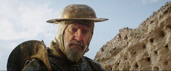 Movie still from “The Man Who Killed Don Quixote” (2018), directed by Terry Gilliam – An old man with a beard wearing a hat; Close Up shot, Low angle