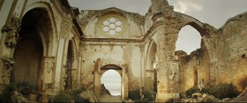 Movie still from “The Man Who Killed Don Quixote” (2018), directed by Terry Gilliam – An old building with a large window in the middle of it; Extreme Wide shot, Low angle