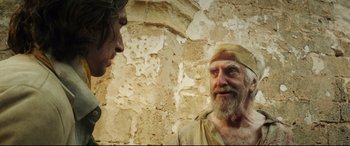 Movie still from “The Man Who Killed Don Quixote” (2018), directed by Terry Gilliam – An old man talking to a young man in front of an old wall; Medium shot, Over the shoulder angle