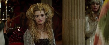 Movie still from “The Man Who Killed Don Quixote” (2018), directed by Terry Gilliam – A woman in a gold headpiece with long blonde hair; Close Up shot, Over the shoulder angle