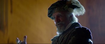 Movie still from “The Man Who Killed Don Quixote” (2018), directed by Terry Gilliam – An old man with a white beard wearing a green hat; Close Up shot, Over the shoulder angle