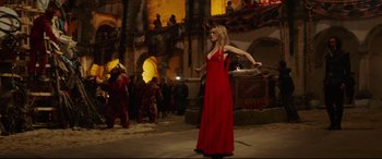 Movie still from “The Man Who Killed Don Quixote” (2018), directed by Terry Gilliam – A woman in a long red dress holding a frying pan; Wide shot, Low angle