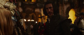 Movie still from “The Man Who Killed Don Quixote” (2018), directed by Terry Gilliam – A man with long black hair standing in front of a crowd of onlookers; Medium shot, Over the shoulder angle