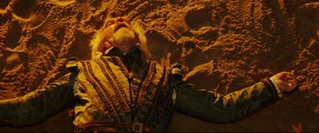 Movie still from “The Man Who Killed Don Quixote” (2018), directed by Terry Gilliam – A man laying on the ground in the sand; Medium shot, Overhead angle