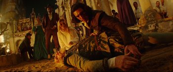 Movie still from “The Man Who Killed Don Quixote” (2018), directed by Terry Gilliam – A group of people standing around a man laying on the ground; Wide shot, Low angle