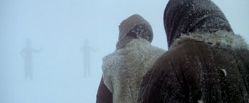 Movie still from “The Man Who Would Be King” (1975), directed by John Huston – Two people standing in the middle of a snowy field; Wide shot, Over the shoulder angle