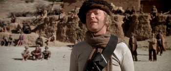 Movie still from “The Man Who Would Be King” (1975), directed by John Huston – A man wearing a fur hat and a scarf; Medium shot, Low angle