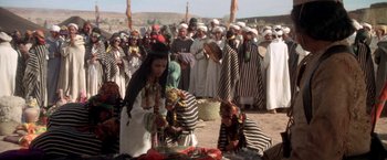 Movie still from “The Man Who Would Be King” (1975), directed by John Huston – A group of men and women standing in a field; Wide shot, High angle