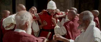 Movie still from “The Man Who Would Be King” (1975), directed by John Huston – A group of men in red and white uniforms fighting each other; Medium shot, High angle