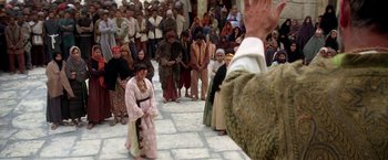 Movie still from “The Man Who Would Be King” (1975), directed by John Huston – A group of people standing in front of a crowd; Wide shot, Over the shoulder angle