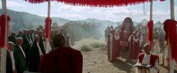 Movie still from “The Man Who Would Be King” (1975), directed by John Huston – A group of people standing in a field; Extreme Wide shot, High angle