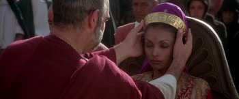 Movie still from “The Man Who Would Be King” (1975), directed by John Huston – A man putting a crown on a woman's head; Close Up shot, Over the shoulder angle