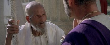 Movie still from “The Man Who Would Be King” (1975), directed by John Huston – An old man talking to a man wearing a purple shirt; Close Up shot, Over the shoulder angle