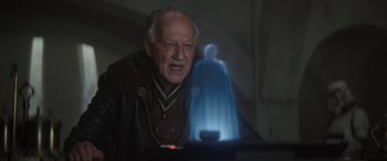 An old man is looking at a glowing figure