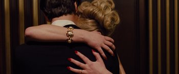 A woman is hugging a man in a black shirt