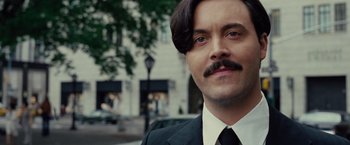 Movie still from “American Hustle” (2013), directed by David O. Russell – A person wearing a suit and tie; Close Up shot, Over the shoulder angle